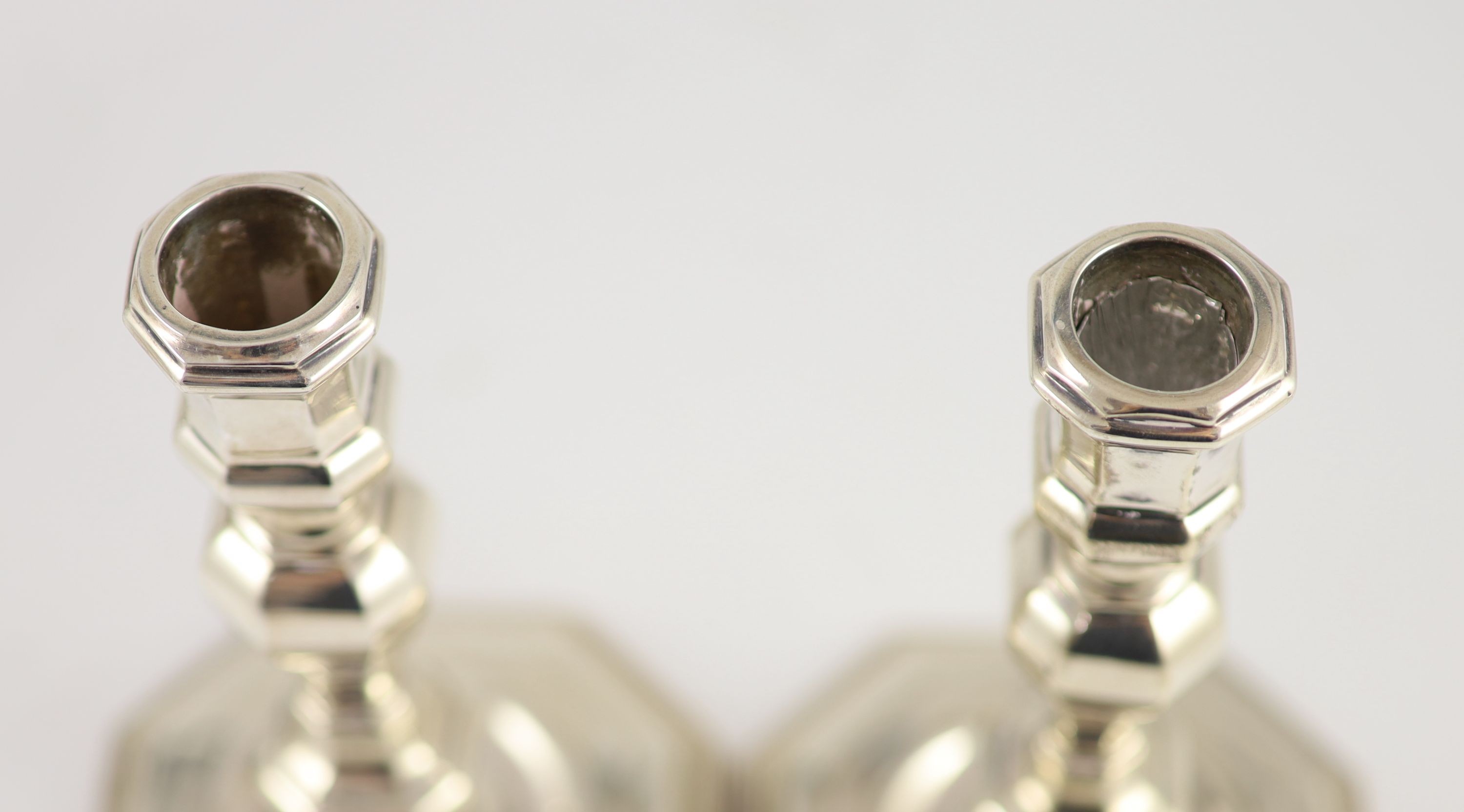 A set of four early 18th century design cast silver candlesticks